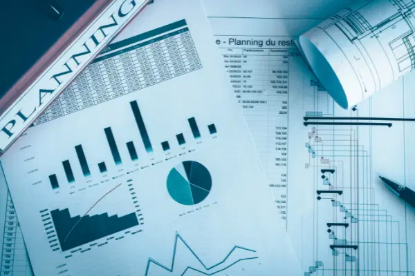 Paper printouts of different charts, including Gantt chart with project plan.